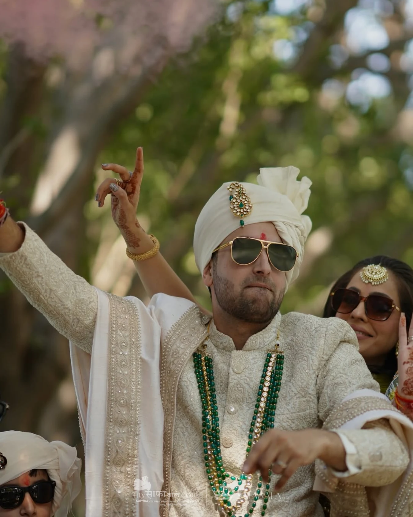 Groom in an ivory wedding safa with emerald jewellery