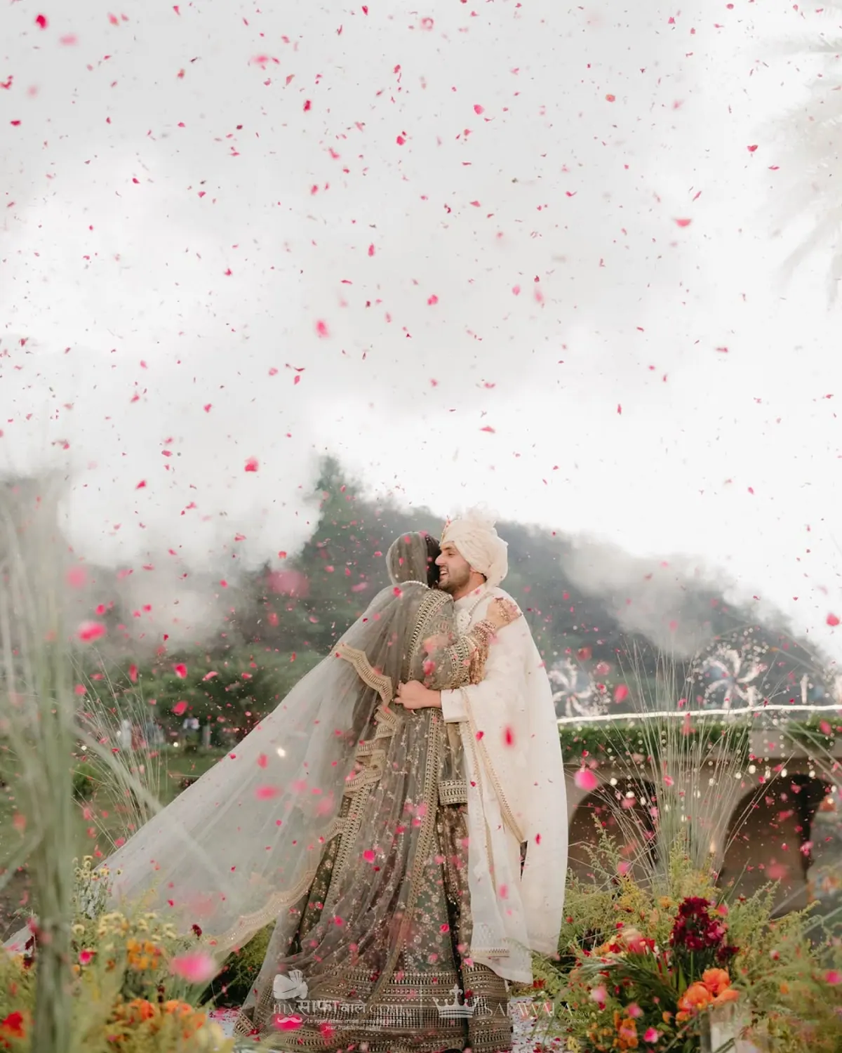 Groom in an ivory wedding safa celebrating under rose petals